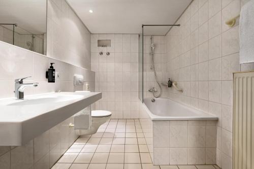 y baño con lavabo, bañera y aseo. en Good Morning Halle Leipzig, en Halle an der Saale