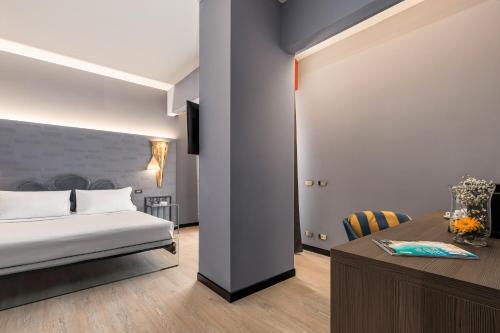 a hotel room with a bed and a desk at City Style Hotel Reggio Emilia in Reggio Emilia