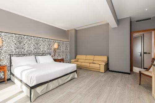a bedroom with a bed and a couch at City Style Hotel Reggio Emilia in Reggio Emilia