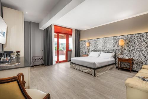 una camera d'albergo con letto e divano di City Style Hotel Reggio Emilia a Reggio Emilia