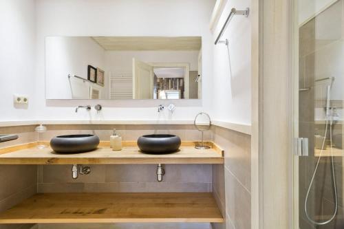 La salle de bains est pourvue de 2 lavabos noirs et d'un miroir. dans l'établissement Luderna - Dúplex Cap de Aran A1, à Baqueira-Beret