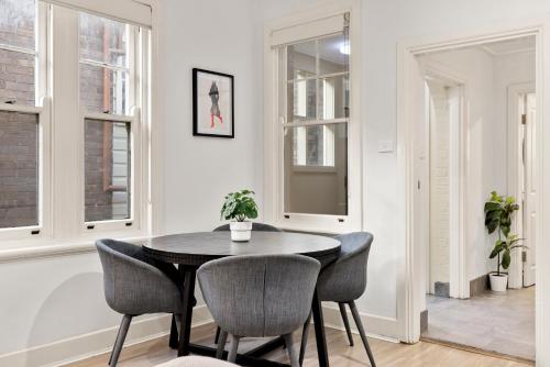 a dining room with a black table and chairs at Perfect Holiday Home with Private Rooftop in Sydney
