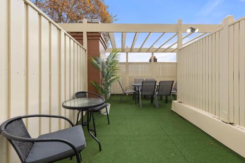 a patio with chairs and tables and a pergola at Perfect Holiday Home with Private Rooftop in Sydney