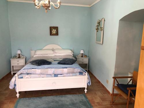 Poggio San Lorenzo的住宿－Il Castelletto Casa Vacanza，卧室配有白色的床和2个床头柜