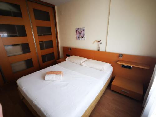 een slaapkamer met een wit bed en 2 handdoeken bij Elsi's place in Premiá de Mar