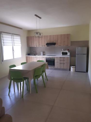 uma cozinha com uma mesa e cadeiras verdes em Casa di campagna pace e tranquillità em Brentanella
