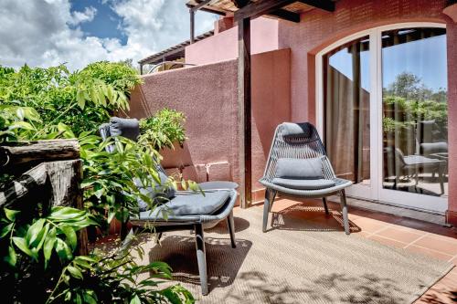a patio with two chairs and plants on a house at Veridia Resort Sardinia, a member of Radisson Individuals in Chia