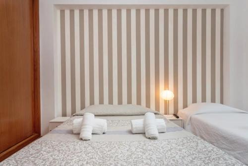 a bedroom with two beds and a striped wall at BLife Candya private rooms in Faro