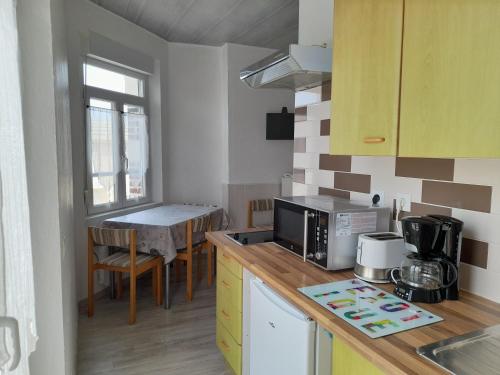 - une cuisine avec un comptoir, un four micro-ondes et une table dans l'établissement Le Mistral Berck, à Berck-sur-Mer