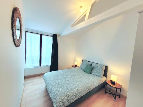 une chambre avec un lit et une grande fenêtre dans l'établissement Appartement 2 chambres centre-ville avec terrasse, à La Rochelle