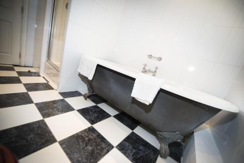 a bathroom with a black and white checkered floor at Columba Hotel Inverness by Compass Hospitality in Inverness