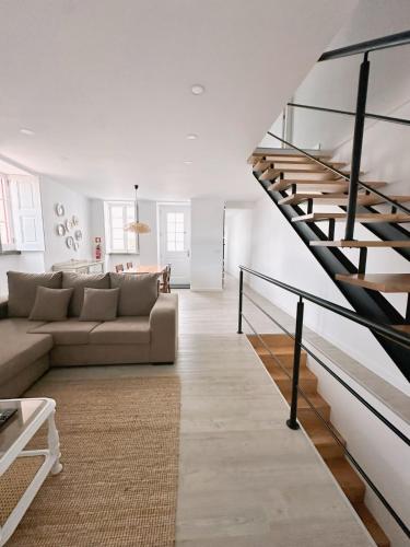 ein Wohnzimmer mit einer Couch und einer Treppe in der Unterkunft Casa Boa Vista - Charming House in Angra do Heroísmo