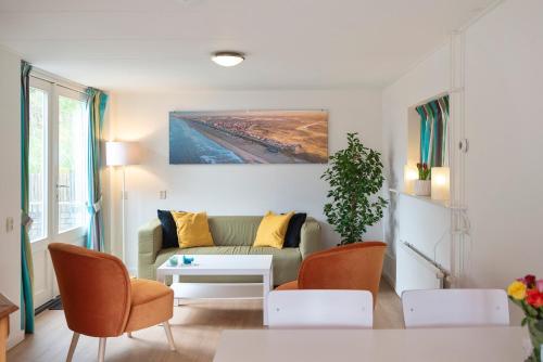 een woonkamer met een bank en een tafel bij Anne's Huisje with private parking in Zandvoort