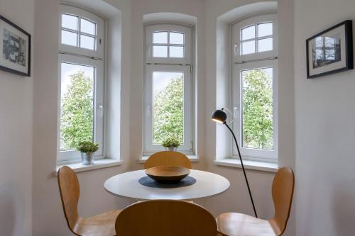 a dining room with a table and chairs and windows at Designhotel 1690 & Apartments in Rendsburg