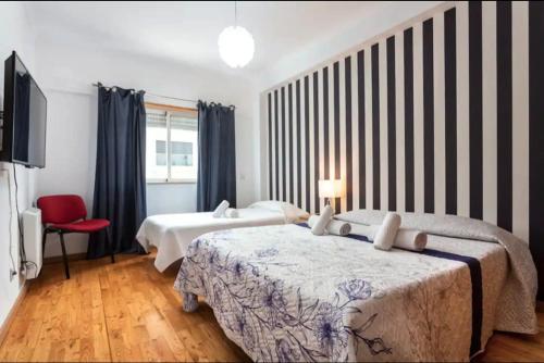 a hotel room with two beds and a television at Blife Candya private rooms in Faro