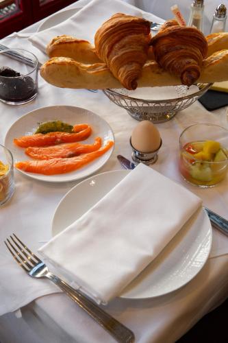 a table with plates of pastries and other foods at Hôtel Le Relais Saint-Germain in Paris