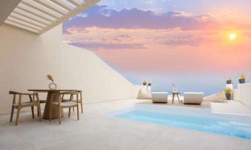 a dining room with a view of the ocean at Pnoe Luxury Suites in Fira
