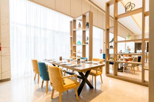 une salle à manger avec une grande table et des chaises dans l'établissement Holiday Inn Lucknow Airport, an IHG Hotel, à Lucknow