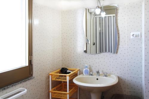 een badkamer met een wastafel en een spiegel bij Il giardino al mare di Anna in Caronia Marina