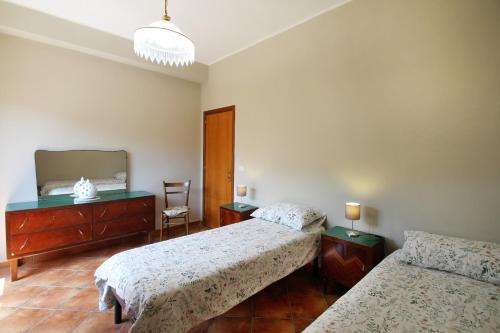 een slaapkamer met twee bedden en een spiegel bij Il giardino al mare di Anna in Caronia Marina