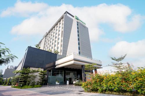 a tall building with a sign on it at Holiday Inn Lucknow Airport by IHG in Lucknow
