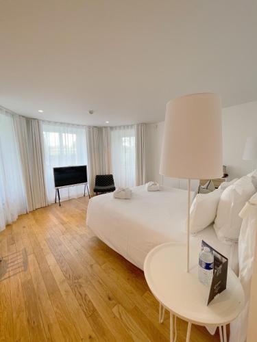 a bedroom with a bed and a table with a lamp at Les Garennes - Hôtel Spa Bénodet in Bénodet