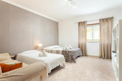 a room with two beds and a couch in it at Blife Candya private rooms in Faro