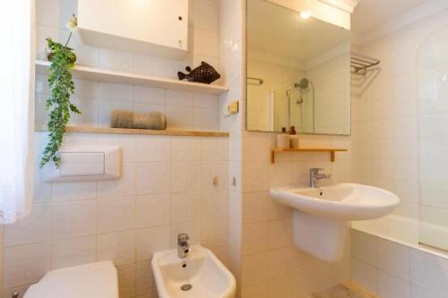ein weißes Bad mit einem Waschbecken und einem WC in der Unterkunft Oliva Nova Villa Mar in Oliva
