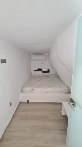 a small white room with a bed in it at Aegean Sunset in Agios Sostis