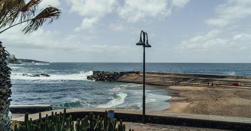 a view of the ocean from a beach with a street light at Apartamento SLAM in Bajamar