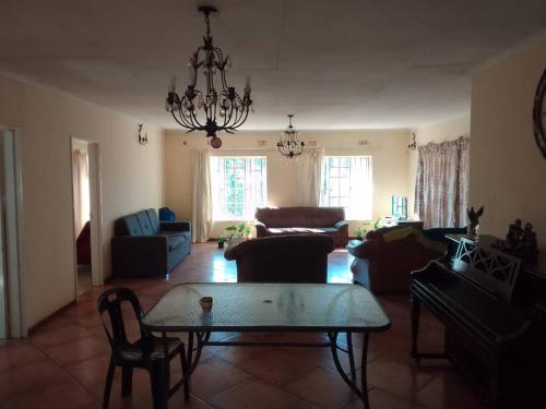 ein Wohnzimmer mit einem Sofa und einem Tisch in der Unterkunft Sugar Shack Backpackers Botswana in Gaborone
