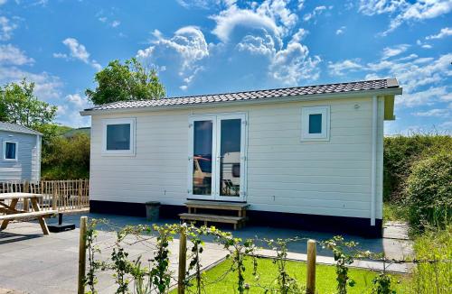 a small white tiny house with a patio at Tiny House in de duinen van IJmuiden aan Zee in IJmuiden