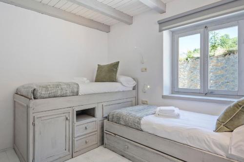 1 Schlafzimmer mit 2 Betten und einem Fenster in der Unterkunft Luderna - Apartamento con jardín Crabera in Arties
