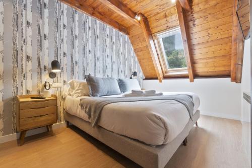una camera con un grande letto e un soffitto in legno di Luderna - Casa Serra Nauta a Tredós
