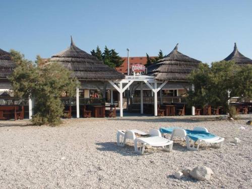 a resort with chairs and tables on a beach at Tribunia Beach Hotel in Tribunj