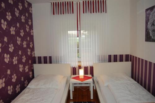 two beds in a small room with a window at Ferienhof Wübbold - Rosenzauber in Rieste