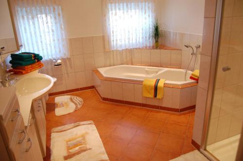 a bathroom with a tub and a sink at Ferienhof Wübbold - Rosenzauber in Rieste