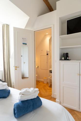 a bedroom with a bed with two towels on it at Les Garennes - Hôtel Spa Bénodet in Bénodet