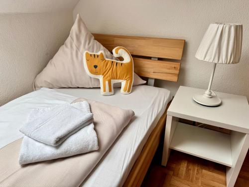 a toy tiger on a bed in a bedroom at Ferienhof Wübbold - Lavendel in Rieste