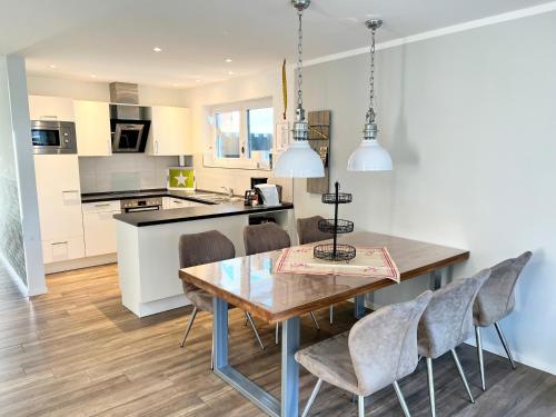 a kitchen and dining room with a wooden table and chairs at Ferienhof Wübbold - 52Nord in Rieste