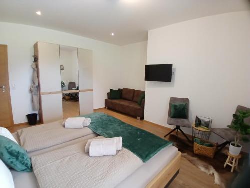 a living room with two beds and a couch at Appartements Kumming - Urlaub inklusive Nationalparkcard in Rauris