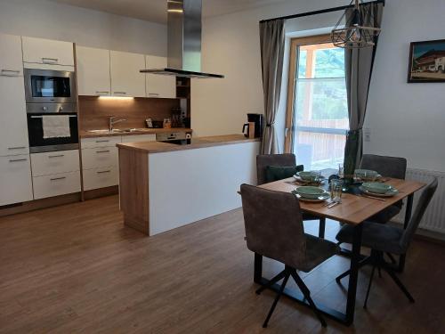 eine Küche mit einem Tisch und Stühlen in der Unterkunft Appartements Kumming in Rauris
