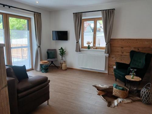 a living room with a couch and a dog laying on the floor at Appartements Kumming - Urlaub inklusive Nationalparkcard in Rauris