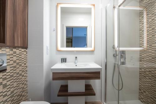 ein weißes Bad mit einem Waschbecken und einer Dusche in der Unterkunft Bel Mare 207 D in Misdroy
