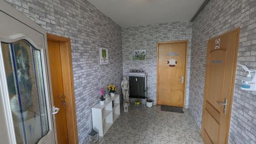 a hallway with a door and a brick wall at Meiks Ferienwohnung in Erfde