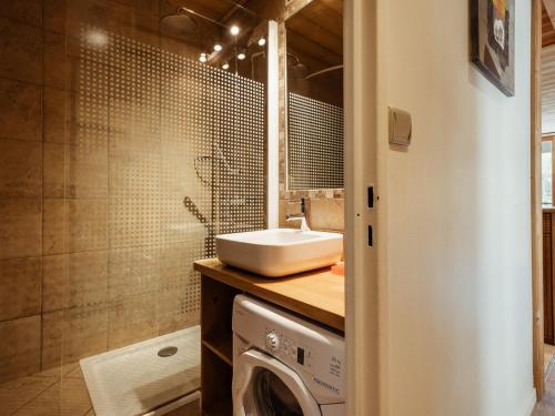 a bathroom with a sink and a washing machine at Appartement La Clusaz, 3 pièces, 6 personnes - FR-1-304-77 in La Clusaz