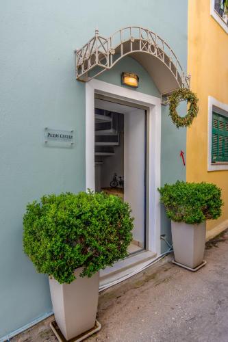 two large plants sitting outside of a building at Paxos Center in Gaios