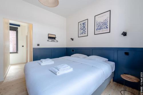 a large white bed with towels on top of it at Petite Dinant - Feet in water hands on the rock in Dinant