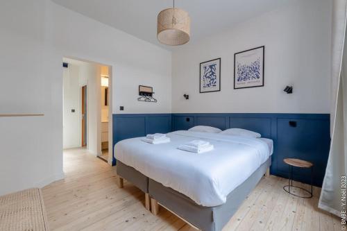 a bedroom with a large bed with a blue headboard at Petite Dinant - Feet in water hands on the rock in Dinant