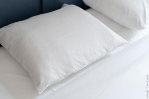 a white pillow sitting on top of a bed at Petite Dinant - Feet in water hands on the rock in Dinant